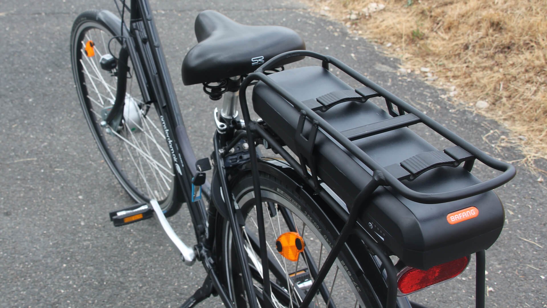 La batterie de ce vélo électrique est logé dans le porte bagages arrière