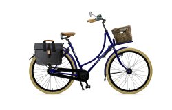 Oma Premium avec cadre bleu nuit, malle en rotin sur le porte-bagage avant et sacoche sur le porte-bagage arrière