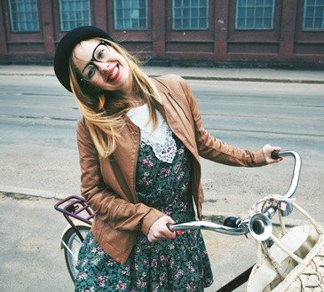 Cheerful  woman with a bike in a street
