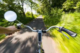 Un vélo avec rétroviseur lancé à pleine vitesse sur une route de campagne
